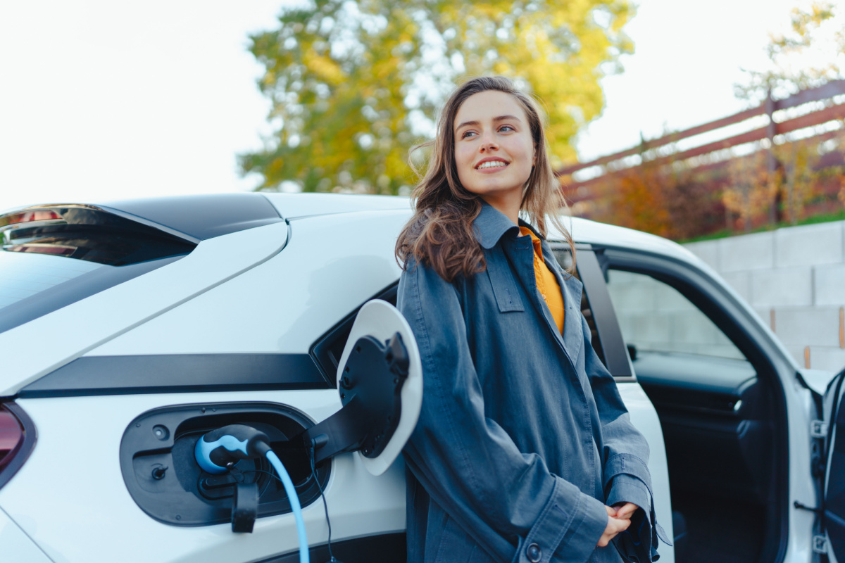 Young adult charging electric car